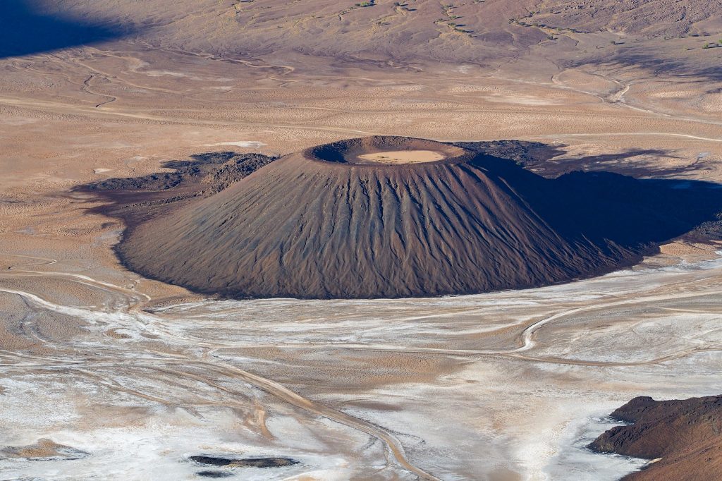 Trou au Natron. Tschad. Reisefotografie. Landschaftsfotografie. XL Digitaldruck auf Acryl Alu Dibond. Panoramadruck "Vulcano" zeigt Vulkankegel in einer riesigen Caldera. Salzablagerungen. Wasserspuren. Chad Republic. XL digital print on acrylic alu dibond. Panoramic image "Vulcano" shows volcano in a hugh caldera. salt deposits. traces made by water. travel photography. landscape photography.