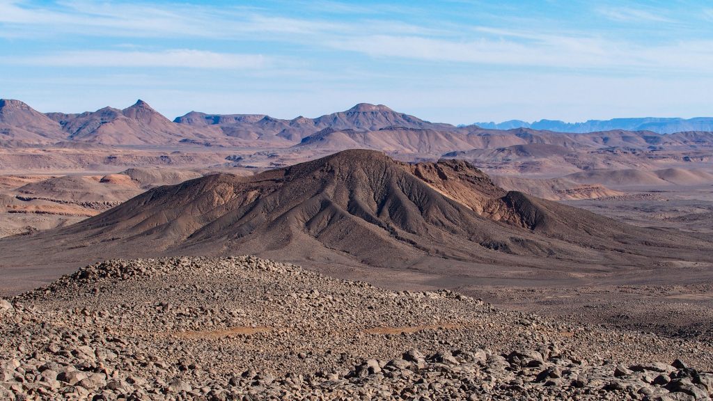 Tschad. Reisefotografie. Landschaftsfotografie. XL Digitaldruck auf Acryl Alu Dibond. Panoramadruck "Tassili Kezen" zeigt endlose steinige Wüstenlandschaft. Vulkanlandschaft mit erodierten Flächen. Chad Republic. XL digital print on acrylic alu dibond. Panoramic image "Tassili Kezen" shows endless stony desert landscape. volcanic landscape with eroded areas. travel photography.landscape photography.