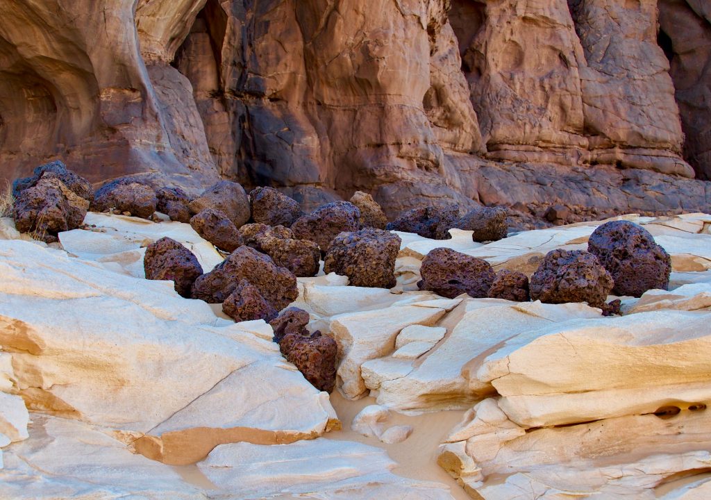 Tschad. Reisefotografie. Landschaftsfotografie. XL Digitaldruck auf Acryl Alu Dibond. Panoramdruck "rocks and stones" zeigt große Manganknollen zwischen Wüstenfelsen. Felsen im Hintergrund. Chad Republic. XL digital print on acrylic alu dibond. Panoramic image "Rocks and Stones" shows hugh manganese nodules in a desert area. rocks in the background. travel photography. landscape fotography.