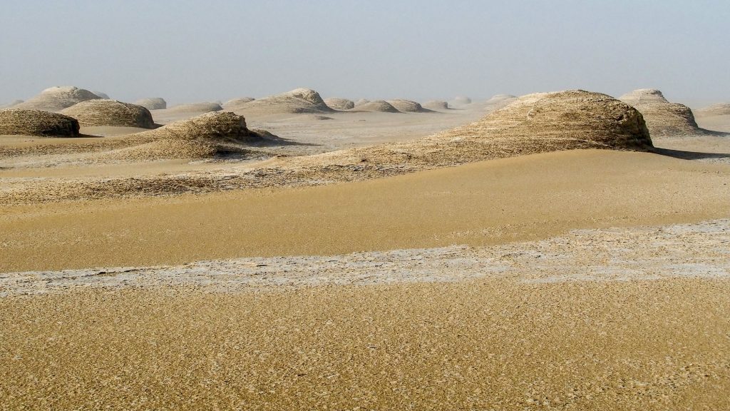 Tschad. Reisefotografie. Landschaftsfotografie. XL Digitaldruck auf Acryl Alu Dibond. Panoramadruck "Erosion" zeigt erodierten Felsen in der Wüste, die sich magisch in die Ferne reihen. Chad Republic. XL digital print on acrylic alu dibond. Image "Erosion" shows eroded rock shapes stretching into the distance. travel photography. landscape photography.